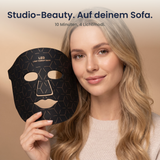 Studio-Beauty auf deinem Sofa – Frau hält die Solvana Glow LED-Maske